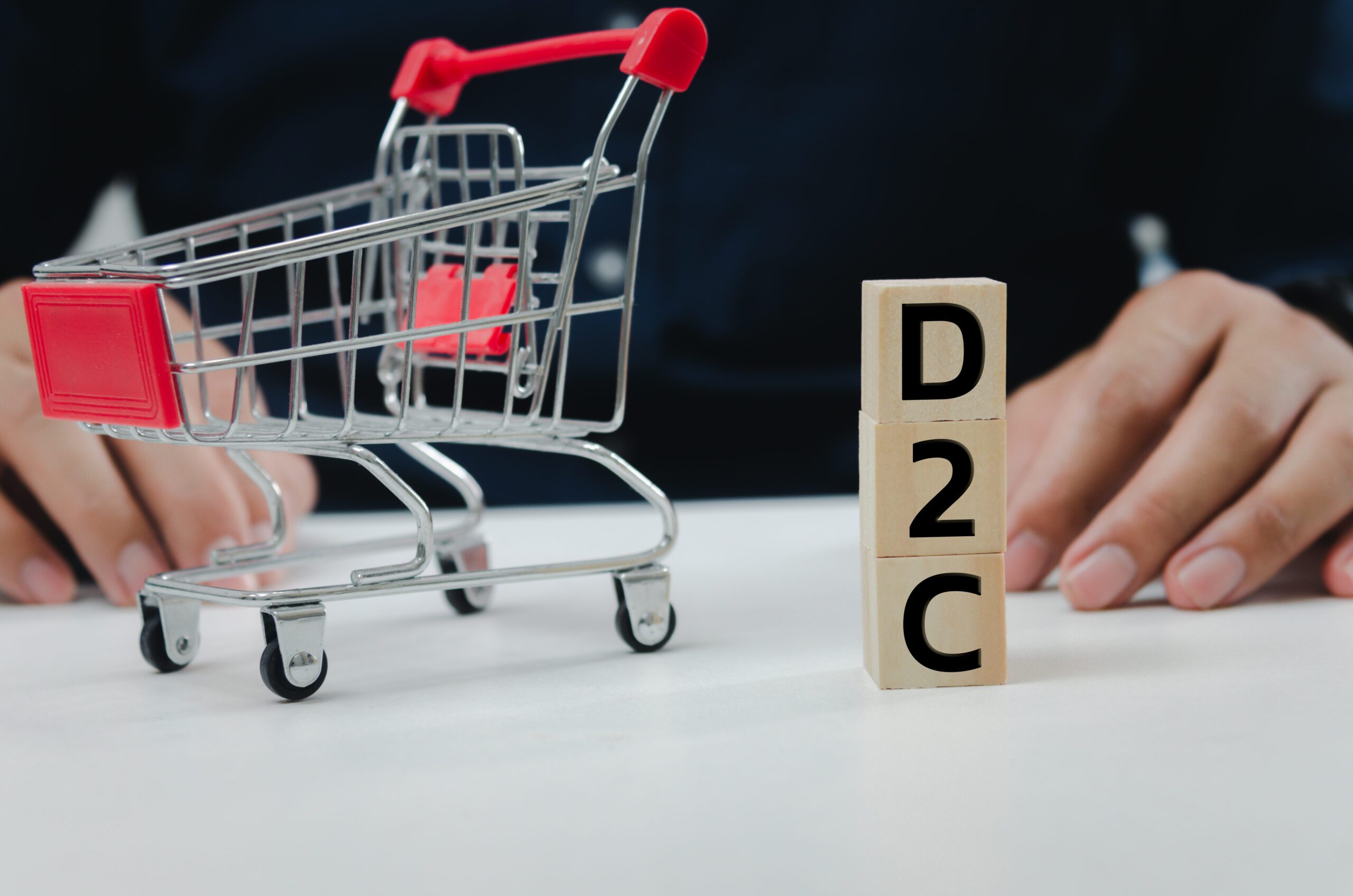 Wood cube block D2C symbol direct to consumer on table.